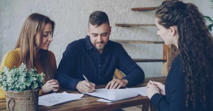 Cash home buyers Texas questions – homeowners reviewing an agreement with a buyer at a table