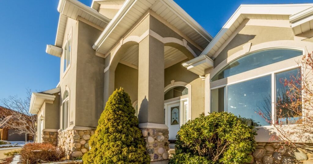 Foreclosure help Dallas TX – two-story stucco home with arched windows and a landscaped yard