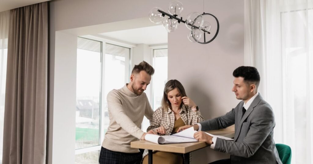 Questions before accepting cash offer house – couple reviewing an offer with a buyer at a table