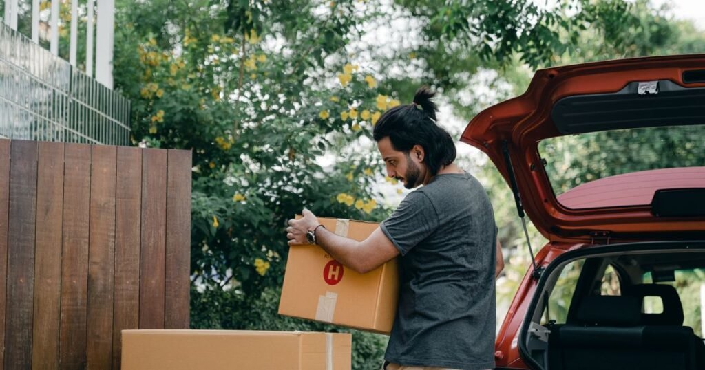 Sell house after relocating Texas – man loading moving boxes into the back of a car