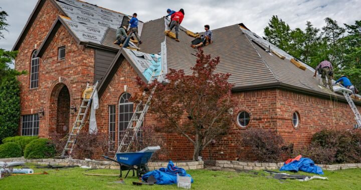 Repair roof before selling house – roofers working on the roof of a brick Texas home